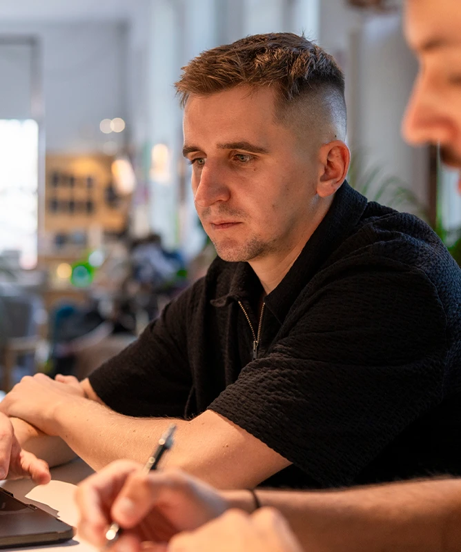 Patryk spogląda na ekran i analizuje.